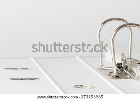 Open office folder with a metal clip and several files on a light background