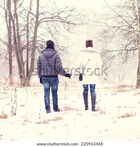 Young couple holding hands in the winter park
