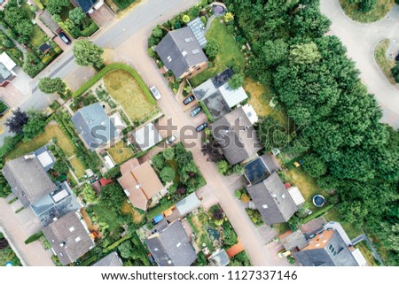 Vertical aerial view of a suburban settlement in Germany with detached houses, close neighbourhood and gardens in front of the houses, drone shot