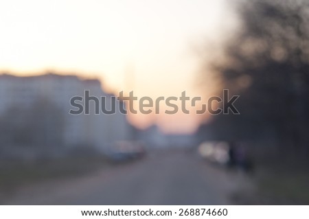 Blurred background: twilight, sunset sky, urban road - houses and park