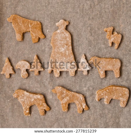 Cooking gingerbread - a shepherd with sheep and dog on baking paper - view from above