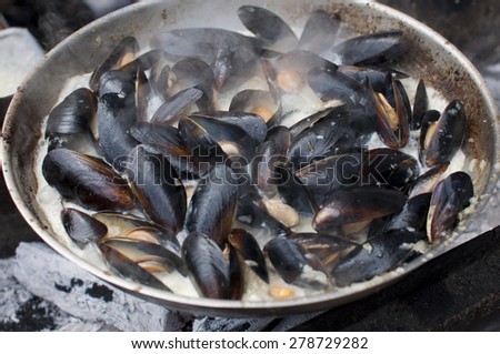 mussels in the  frying pan on grill in food market
