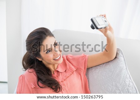 Brunette Sitting On Her Sofa Taking A Picture Of Herself At Home In The Sitting Room