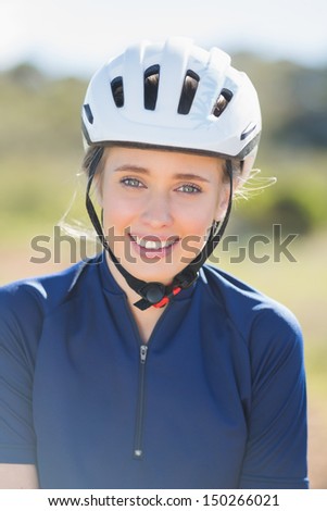 Close up of woman wearing bike helmet looking at camera
