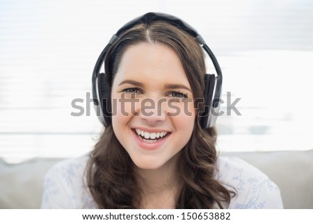 Smiling young woman listening to music in bright living room