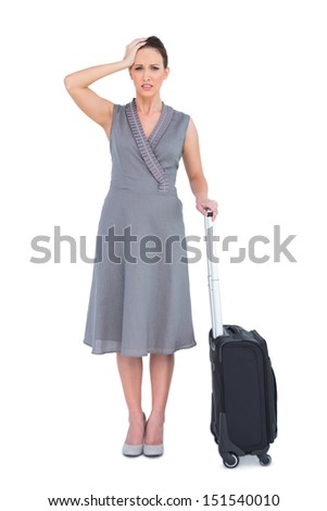 Worried gorgeous woman with suitcase posing on white background