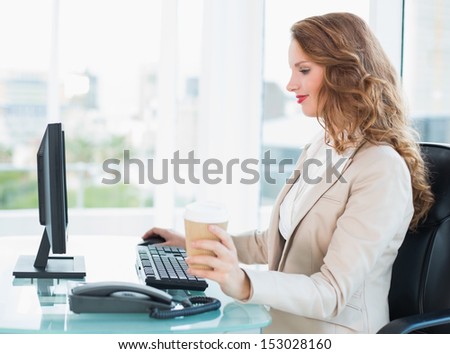 Concentrated pretty businesswoman using computer at office