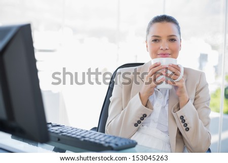 Relaxed sophisticated businesswoman smelling coffee in bright office