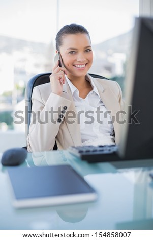 Smiling sophisticated businesswoman on the phone in bright office
