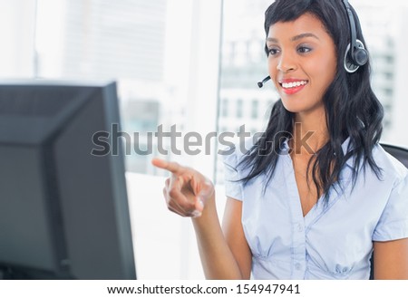 Pretty operator pointing her computer in office