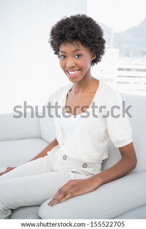Pretty brunette sitting on cosy sofa in bright living room