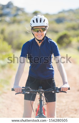 Woman wearing helmet on her bike looking at camera