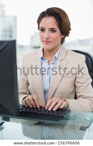 Calm businesswoman looking at computer in bright office