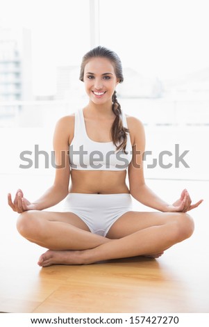 Cheerful relaxed brunette meditating in bright room