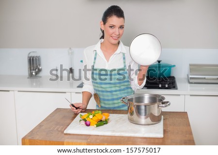 Smiling pretty woman cooking in bright kitchen