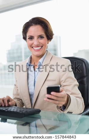 Attractive businesswoman smiling at camera in bright office