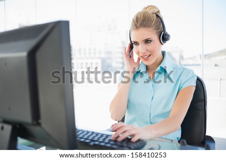 Focused call center agent working on computer in bright office