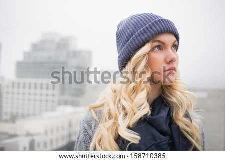 Day dreaming pretty blonde posing outdoors on urban background
