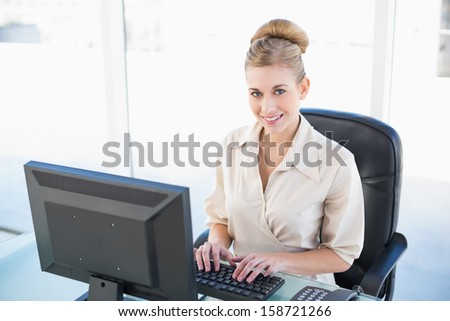 Attractive young blonde businesswoman using a computer at office