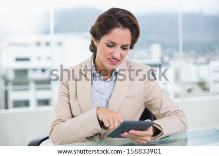 Upset businesswoman using calculator in bright office