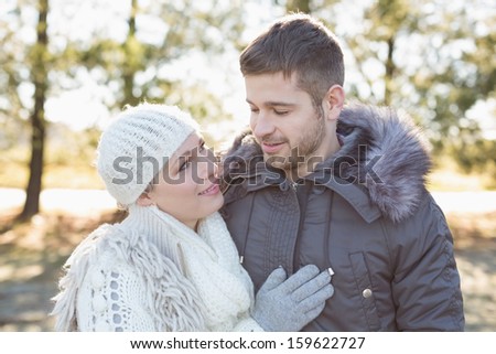 Close-up of a smiling young couple in winter clothing in the woods