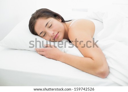 Pretty young woman sleeping in bed with eyes closed