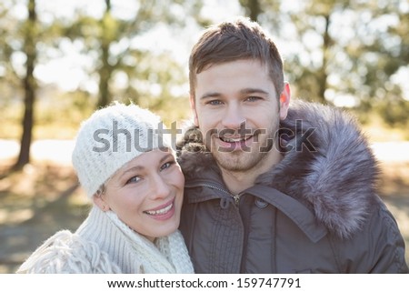 Close-up portrait of a smiling young couple in winter clothing in the woods