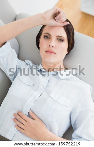 High angle view of a well dressed young woman lying on sofa at home
