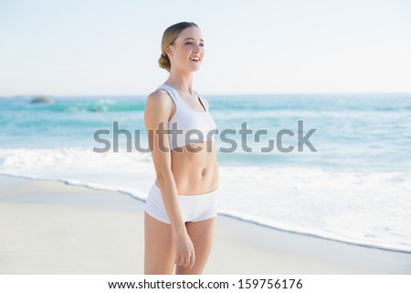 Attractive slender woman looking away standing on the beach