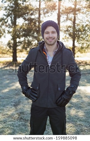Portrait of a young man in warm clothing while having a walk in forest on a winter day