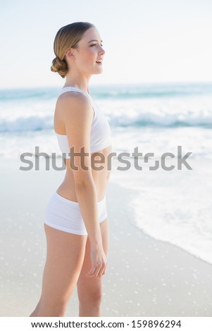 Beautiful slender woman looking away standing on the beach