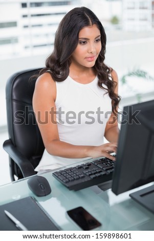 Calm cute businesswoman working at computer in bright office