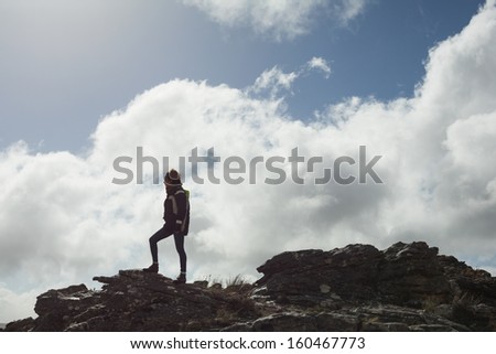 Low angle view of a woman on rock admiring the view after a hike