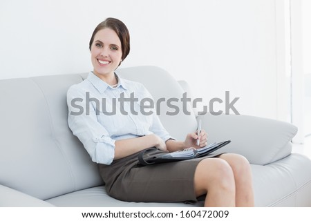 Portrait of a well dressed young woman using personal organizer at home