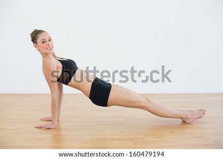 Attractive fit woman in sportswear doing yoga pose looking at camera