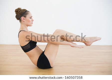 Profile view of beautiful woman doing a sports exercise in sports hall