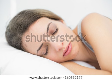 Cute young woman lying on her bed in the bedroom with eyes closed