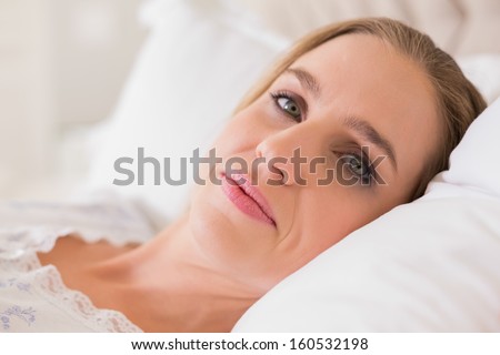Natural content woman resting in bed in bright bedroom