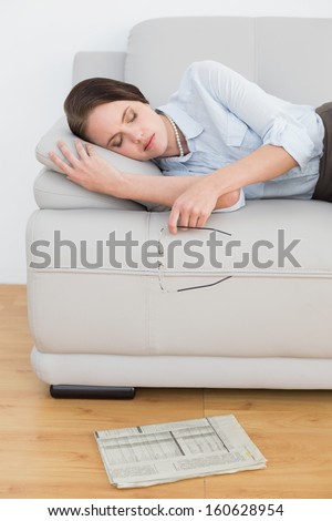 Well dressed young woman sleeping on sofa at home