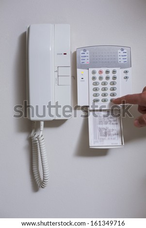 Close up of wall phone and list of numbers on white background