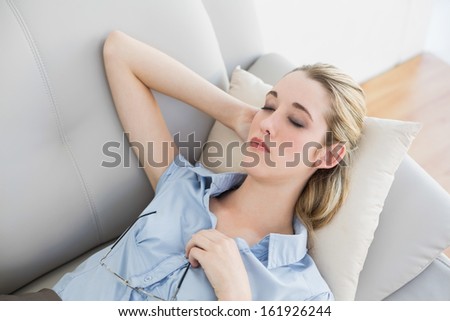 Calm blonde businesswoman lying sleeping on her couch in the office