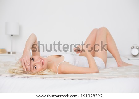 Portrait of a pretty young woman resting in bed at home