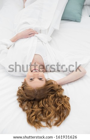 Overhead portrait of a pretty young woman resting in bed at home