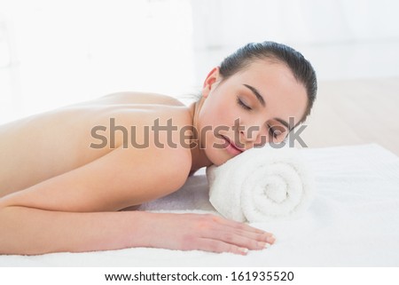 Close up of a topless beautiful young woman resting on towel at beauty spa