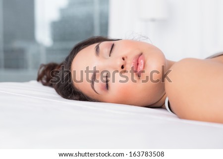 Close-up of a pretty young woman sleeping with eyes closed in bed