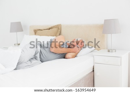 Mature man sleeping peacefully in bed at home