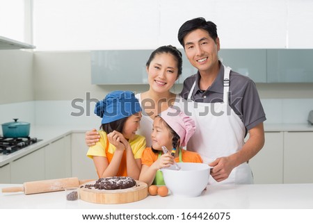 Portrait of a family of four preparing cookies in the kitchen at home