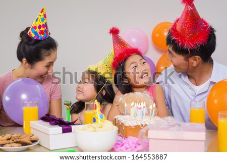 Happy family of four with cake and gifts at a birthday party