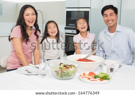 Portrait of a smiling family sitting at dining table in the kitchen at home