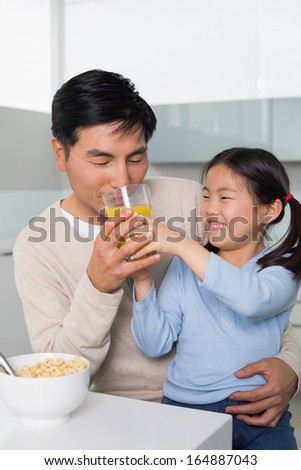 Father with young daughter having breakfast in the kitchen at home